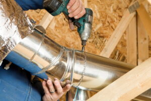 drilling-pieces-of-ductwork-together-in-attic