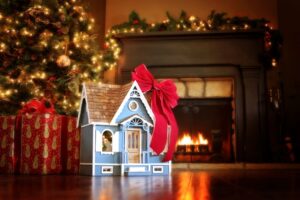 dollhouse-with-red-bow-under-christmas-tree-fireplace-in-background